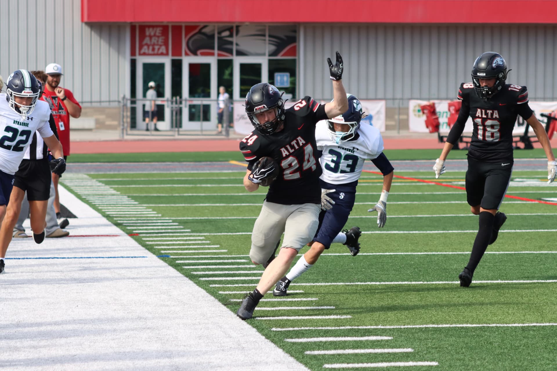 Canyon carrying the football for Alta, pursued by a Syracuse defender