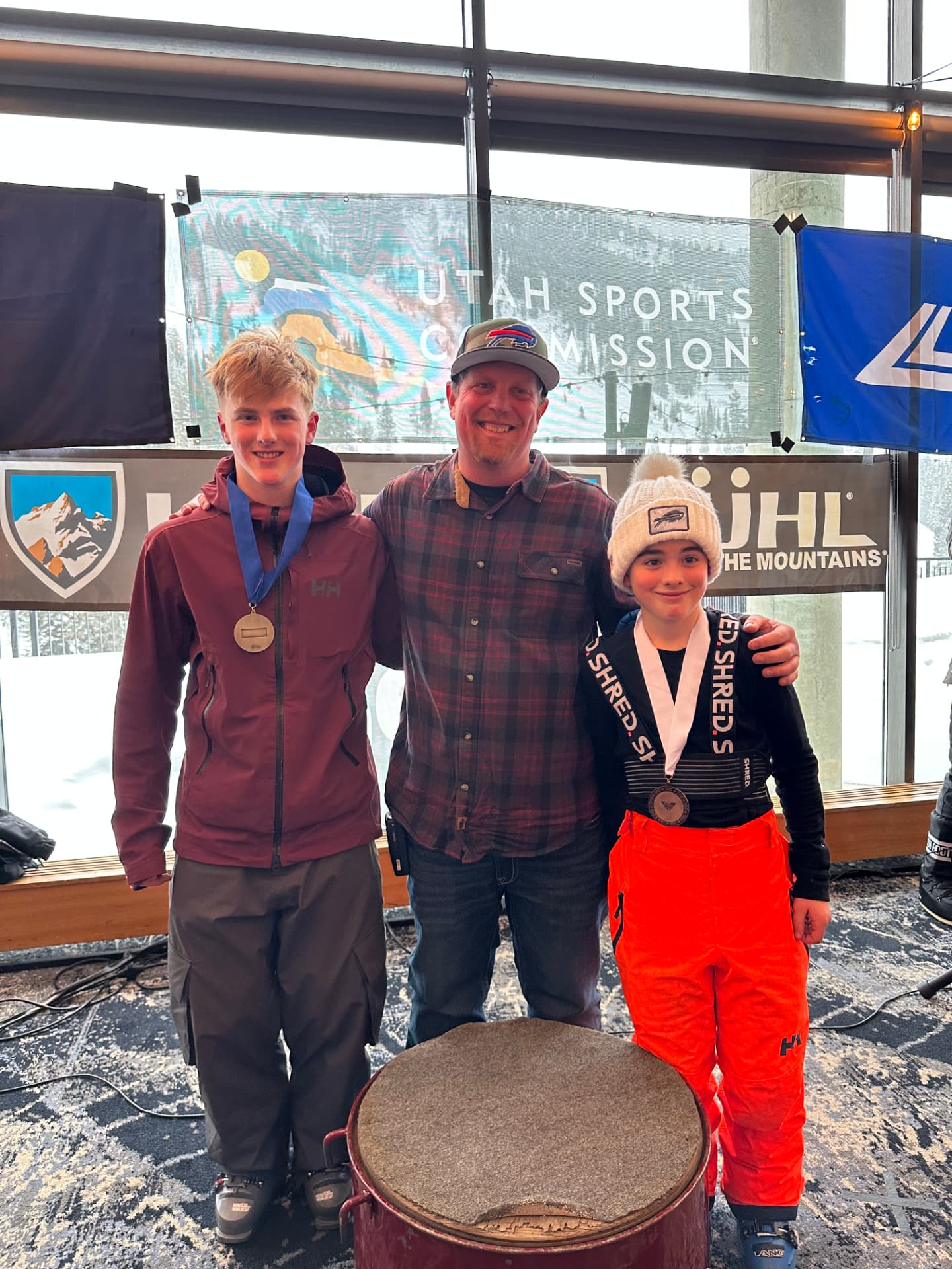 Canyon posing arm in arm with an adult and a young child in front of the awards podium