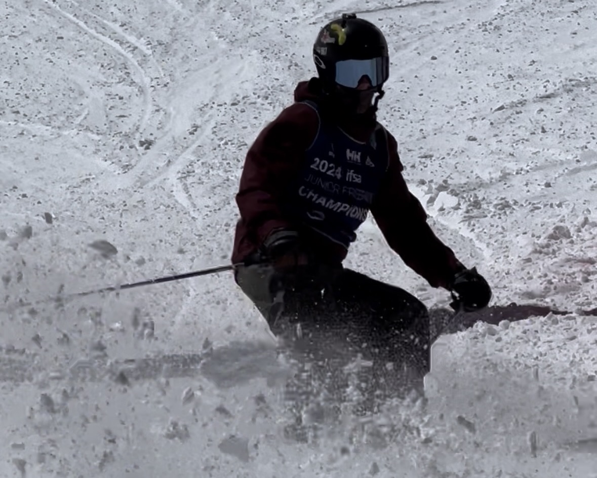 Canyon skiing a competition run at the 2024 IFSA Junior Freeride Championships, wearing his event bib