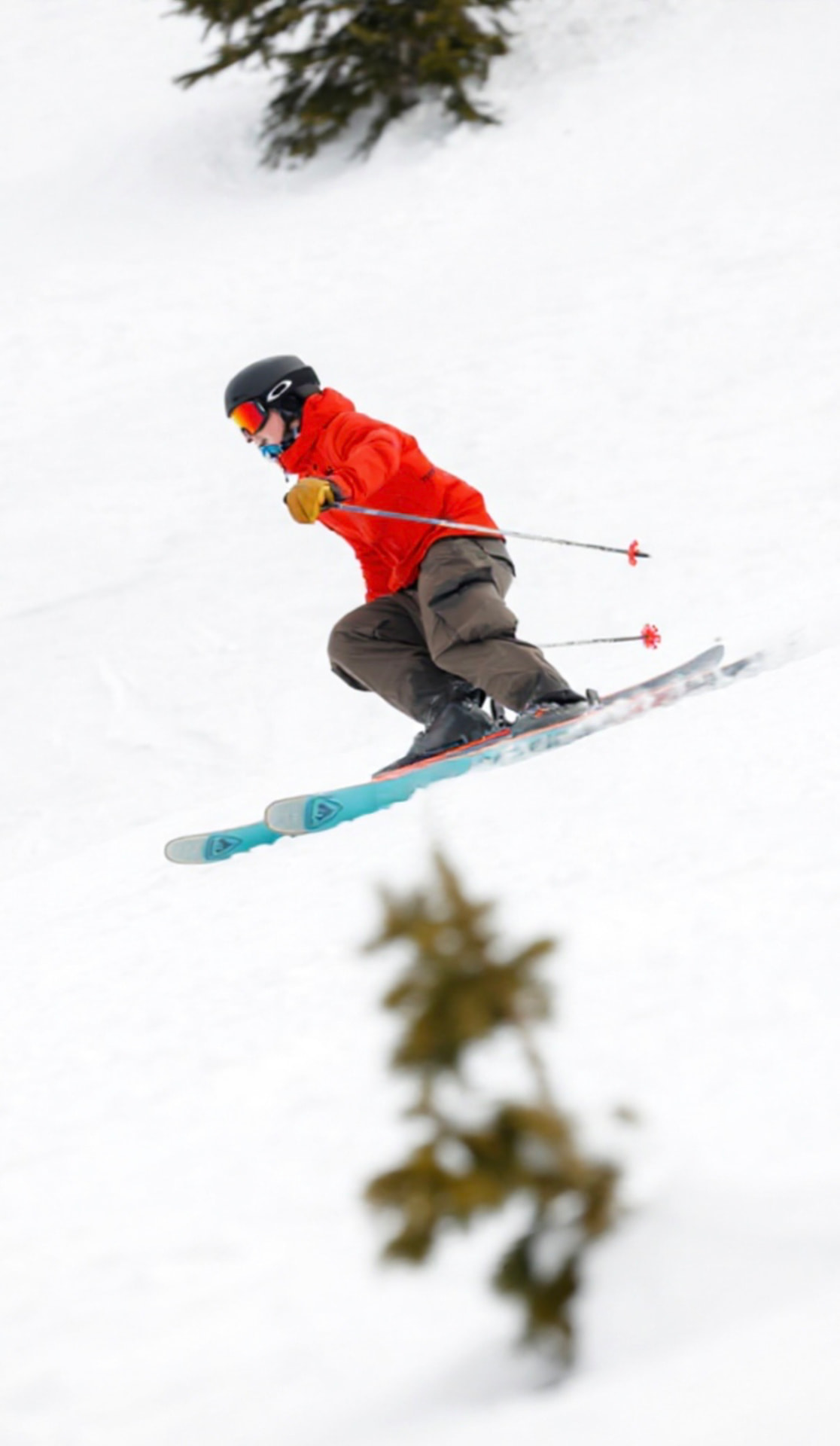 Canyon airborne in a red jacket above the snow